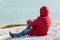 Lonely man sitting on the lakeshore, admiring the nature. Unrecognisable person