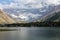 lonely man standing on lake and beautiful landscape with amazing scenic snow capped mountains, Tajikistan,