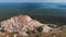 Lonely man standing on the top of rocky mountain and watching the view of dense forest