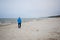 A lonely man trains Nordic walking on the beach of the Baltic Sea