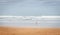 Lonely man walk on seashore on cloudy day. Huge wave on the beach with tourist. Panoramic seascape. Autumn on the coast, Spain.