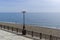 A lonely man walking along the surf line on an empty beach.