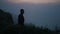 Lonely man walking on mountain at sunrise. Relaxed guy standing on rocky coast