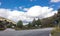 Lonely and moody road with clouds and an interesting light. Mountain road with dramatic colourful sky. Journey, outdoor, travel