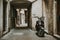 Lonely parked retro scooter in front of one house in old empty narrow alley with stone road of historic town of Piran in Slovenia