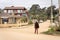 Lonely peasant man walking on empty unpaved street