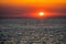 Lonely person riding paddling a sup into a spectacular sunset.