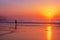 Lonely person walking on beach at sunset