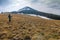 Lonely photographer in mountains with a camera on a tripod in co