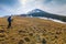 Lonely photographer in mountains with a camera on a tripod in co