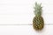 Lonely pineapple on white wood