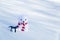 Lonely polar bear toy with a striped scarf and a gift in the snow