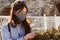 Lonely pretty young woman with long hair in a mask walks during a pandemic on the street