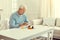 Lonely retired man taking medication out of weekly organizer