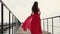 Lonely romantic woman is walking on old empty pier of sea in daytime, back view