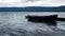 Lonely rowboat tied to floating lake dock bobs gently in waves under cloudy skies near Hurdal, Akershus, Norway