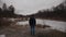 Lonely sad man, standing with his back and looking at frozen lake inforest. Depression, bad mood and suicidal thoughts