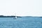 Lonely sailboat crossing a calm bay