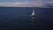 Lonely sailboat plows the expance of the ocean, aerial shoot. Yacht from drone.