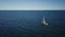 Lonely sailboat plows the expance of the ocean, aerial shoot. Yacht from drone.