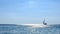 Lonely sailboat sailing on the sea surface, sparkling blue sea, panning lens