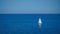 A lonely sailing boat dances on the canvas of clear blue waters, a symphony of maritime solitude