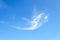 Lonely scenic translucent cirrus cloud high in the blue summer sky. Different cloud types and atmospheric phenomena