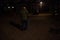 Lonely senior man walking on French street at night using walking stick