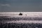 A lonely ship in the sea near a buoy at dusk.