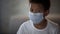 Lonely sick Afro-American boy in face mask on blurred background, quarantine