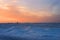 Lonely silhouette of a seated man in the icy desert on a sunset