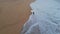 Lonely surfer walking beach drone view. Foamy ocean waves covering sandy shore