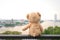 Lonely teddy Bear sitting river view. Chao Phraya river in Bang
