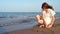 Lonely teen girl draws a heart in the sand