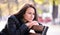 Lonely thoughtful young woman sitting alone on street bench outdoors. Solitude and depression concept