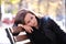 Lonely thoughtful young woman sitting alone on street bench outdoors. Solitude and depression concept