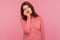 Lonely tired woman in pink sweater leaning head on hand, looking with bored expression, exhausted with overwork