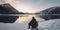 lonely tourist with backpack sitting near the Mountain Lake