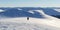 Lonely tourist walking on snowy mountain range