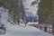 A lonely tourist walks in the winter by a mountain valley