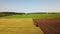 Lonely tractor plow the wheat field.