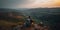 lonely traveler with backpack sitting in mountains