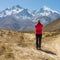 Lonely trekker on a crossroad of two roads towards mountains.