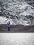 Lonely turist girl near a glacier taking pictures