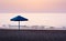 Lonely umbrella on empty beach at dusk