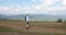 Lonely walk in the mountains. Handsome young man walks along the hill with a backpack on his shoulders and looks around