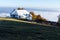 A lonely white house on top of a mountain. The house is above the clouds. House and mountain landscape.