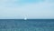 Lonely white yacht floating on the horizon on the Baltic Sea.