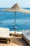 Lonely wicker sun umbrella at mediterranean beach by sea. Natural bamboo sunshades and summer umbrella parasol on ocean beach.
