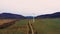 Lonely windmill in the field between Carpathian mountains of Ukraine in spring against a background of cloudy sky